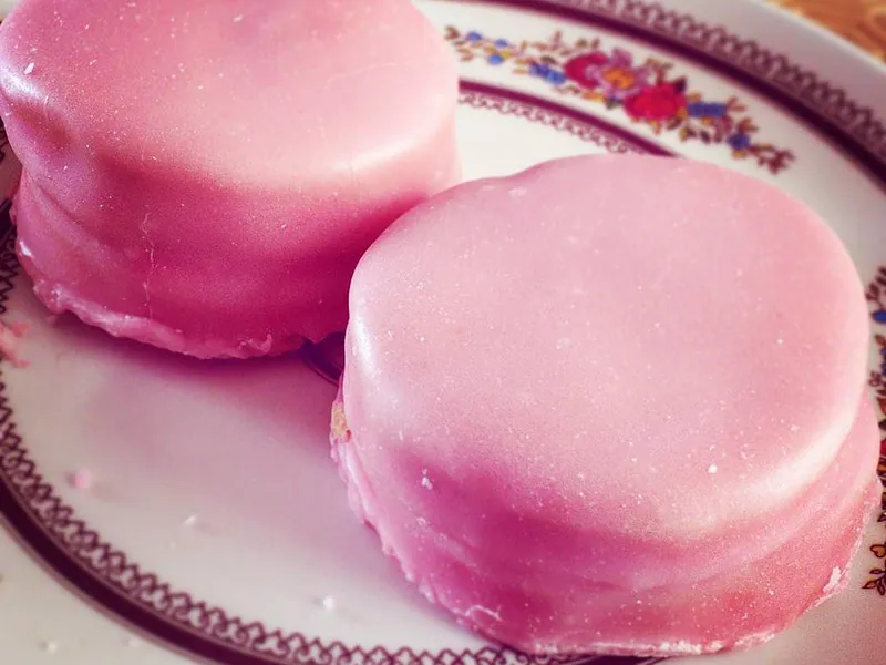 Two pink napolitaine biscuits on a plate
