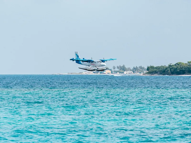Seaplane flying low over turquoise water